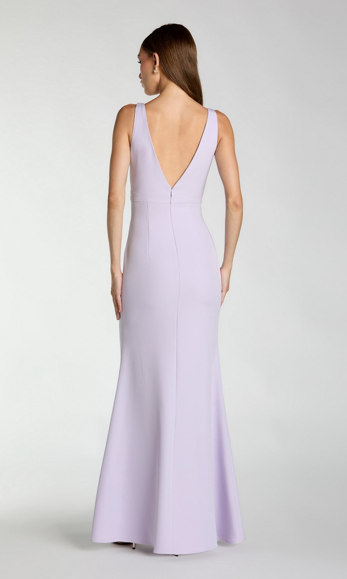 A woman faces away, showcasing the Mac Duggal 2371—an elegant long formal dress in light lavender crepe with a sleeveless design and deep V-back.